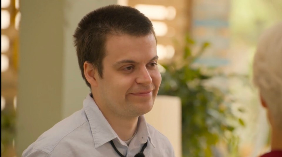 Man smiling and looking off to the side.