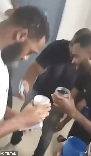 Incarcerated criminals seen gathered around enjoying drinks while they sing and party in their cell