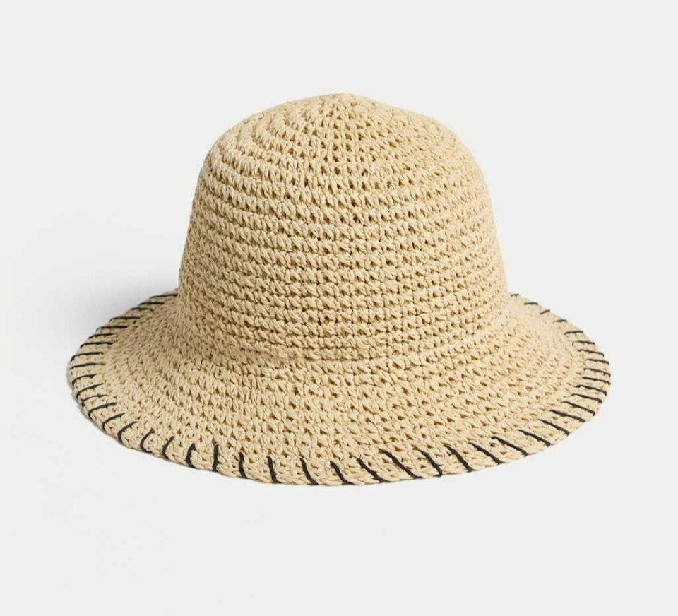 Beige crochet bucket hat with black stitching.