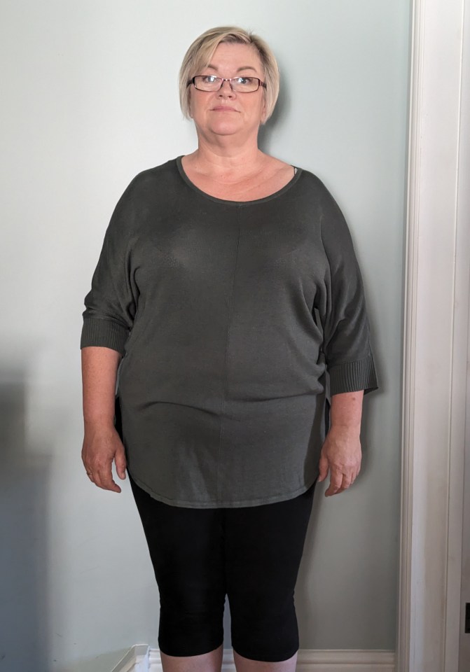 Woman in dark green top and black leggings.