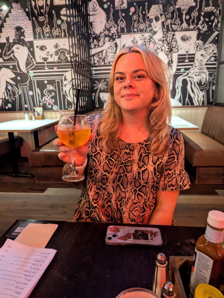 Woman holding a cocktail in a restaurant.
