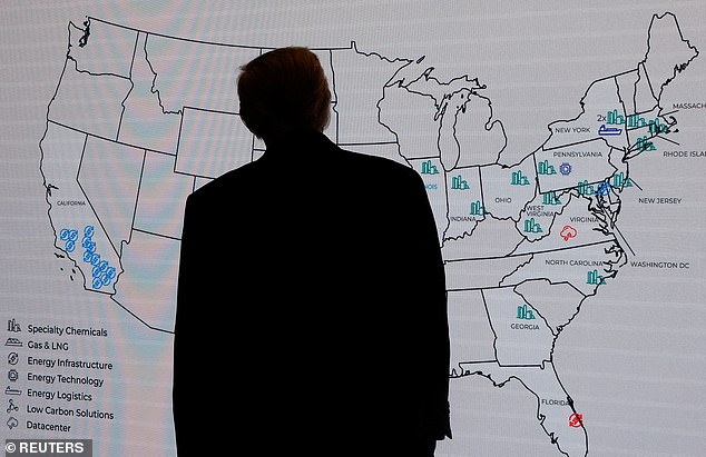 President Donald Trump looks at a display during a business forum in Abu Dhabi