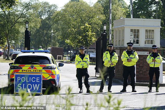 Police officers patrol at a cordon near the scene of a fire at Bicester Motion in Oxfordshire