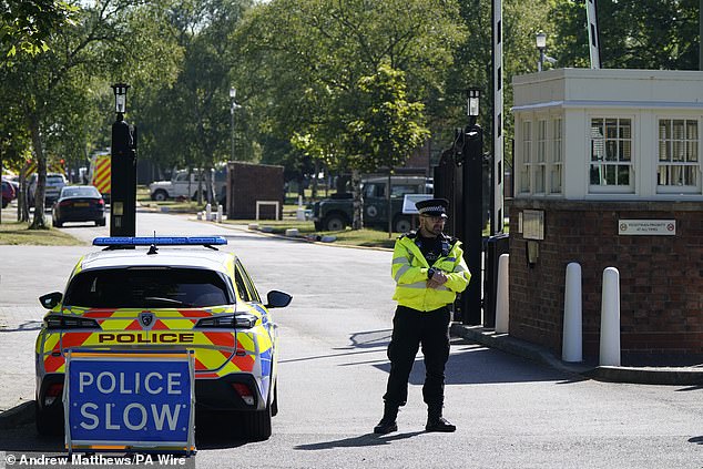 Police officers patrol at a cordon near the scene of a fire at Bicester Motion in Oxfordshire