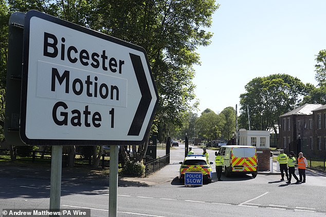 Police officers patrol at a cordon near the scene of a fire at Bicester Motion in Oxfordshire