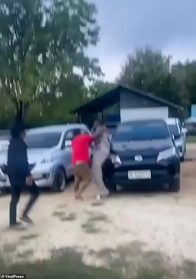 A man in beige is also seen being beaten in the scrap, with locals seen chasing him at one point