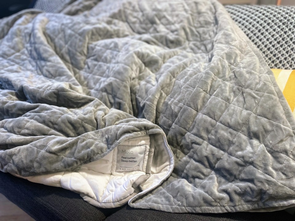 Gray weighted blanket on a couch.