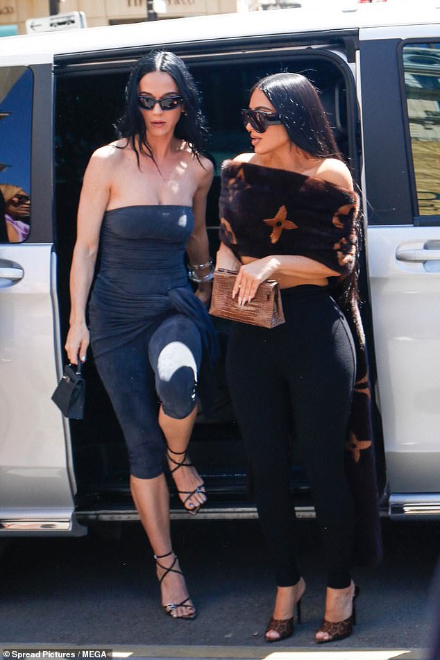 Katy, 40, opted to go braless in a figure-hugging bandeau dress with sash detailing that cinched in her slender waist