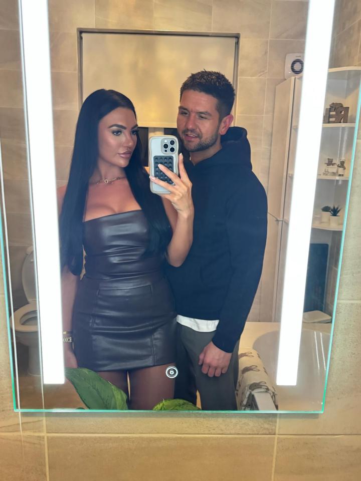 Mirror selfie of a couple in a bathroom.