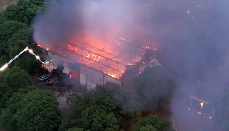 Aerial view of a large building engulfed in flames.