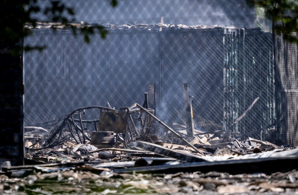 Debris and smoke at the site of a fire.