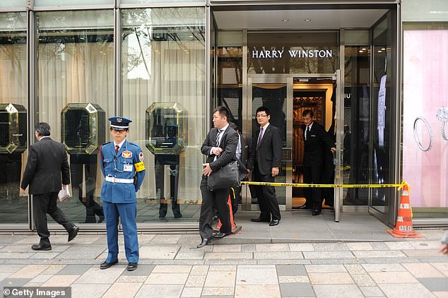 A security guard stands in front of the closed Harry Winston jewellery store on the ground floor of the Omotesando Hills shopping complex in Tokyo on November 22, 2015, following the alleged robbery