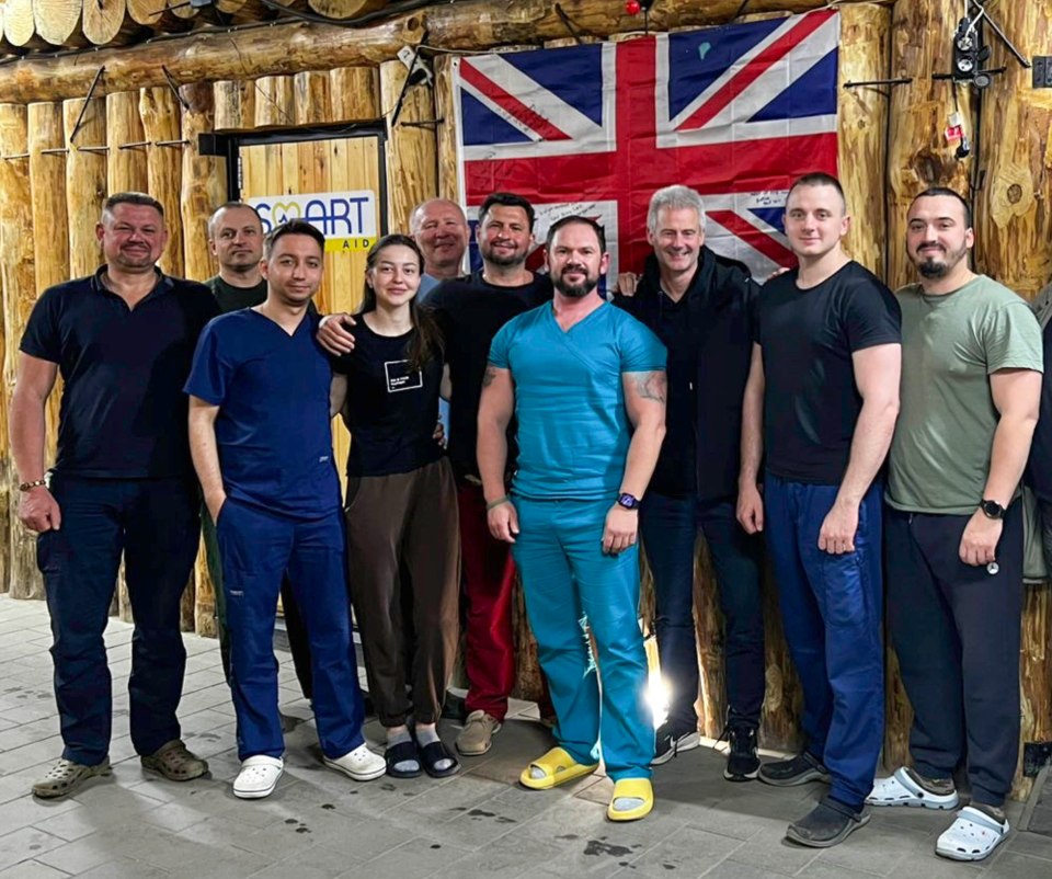 Group photo of medical personnel in front of a UK flag.