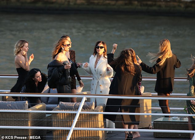 The journalist wrapped up in a white coat as she danced with her pals