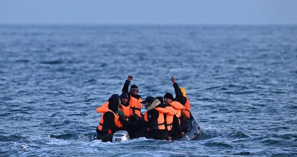Migrants in a small boat at sea.