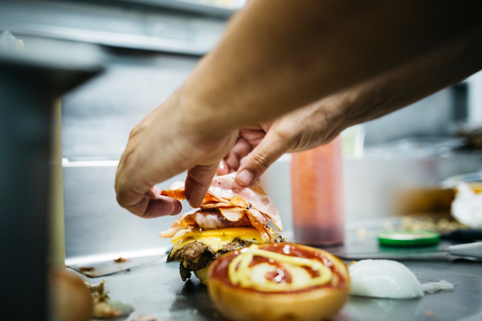 Chef preparing a cheeseburger.