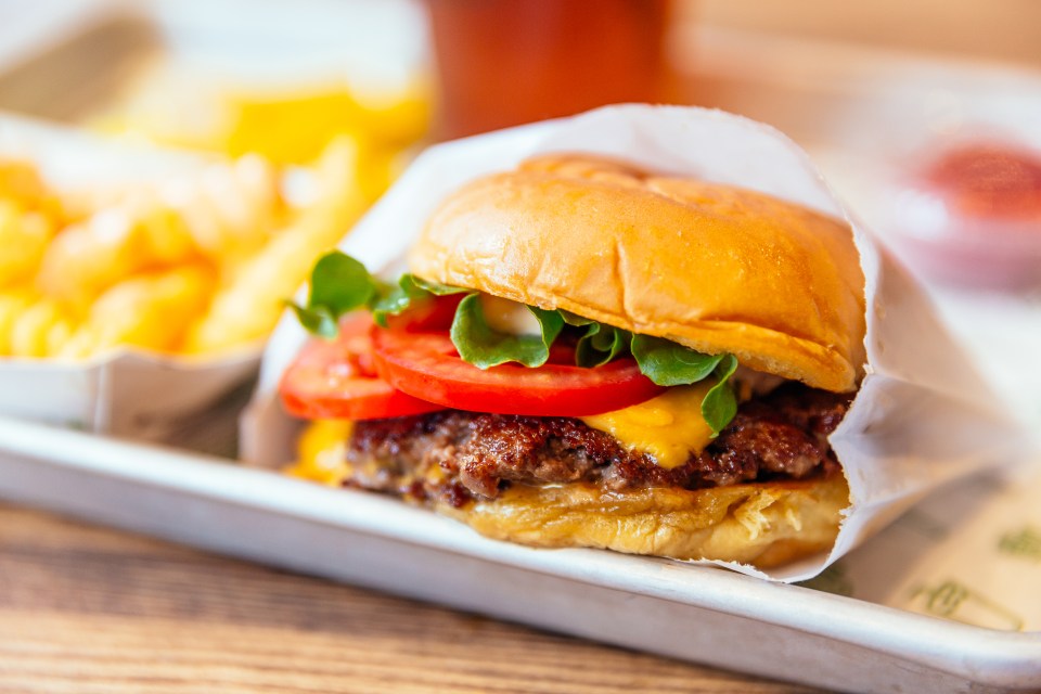 Cheeseburger with lettuce and tomato, served with french fries.