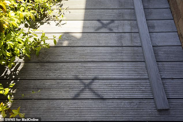 Mr Chapman has marked Xs on the broken composite decking boards which he says were caused by the crew who 'made some very basic mistakes' which have made it unsafe