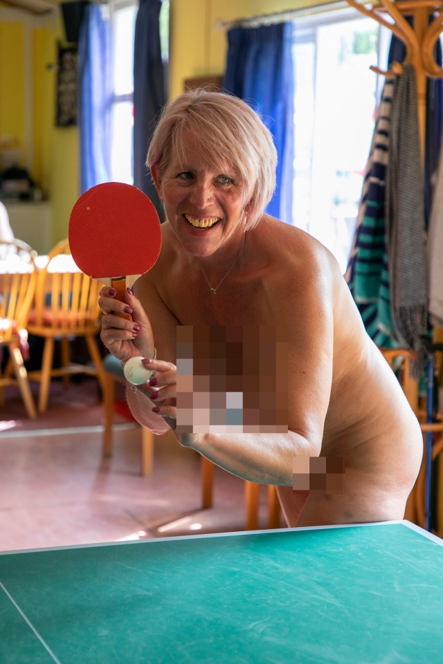 A nude woman playing table tennis.