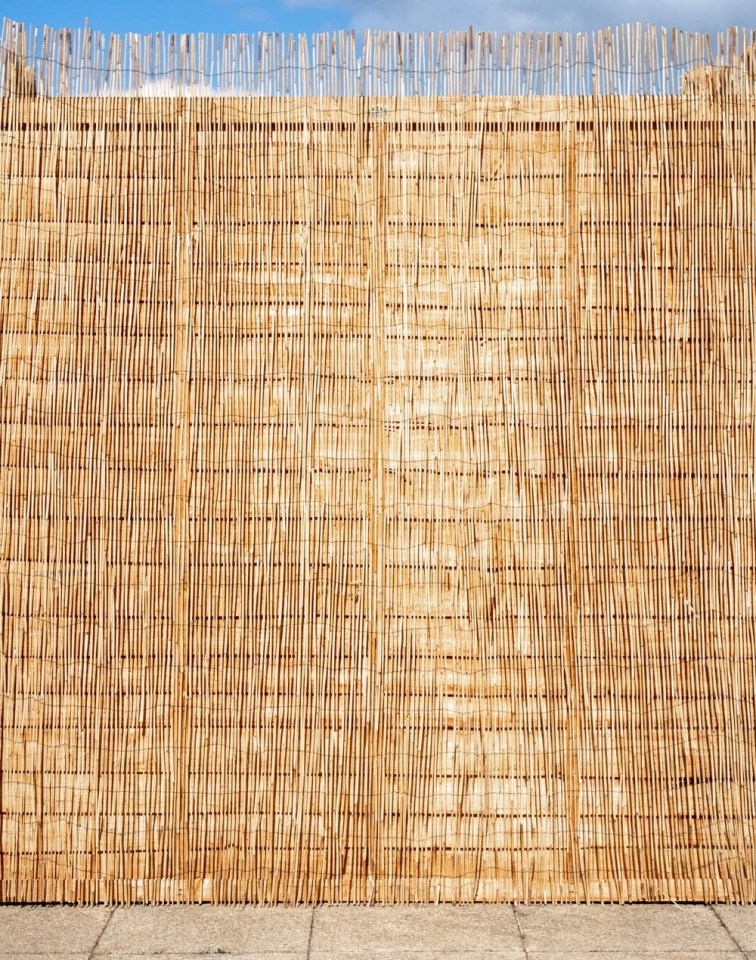 Privacy fence made of woven reeds.