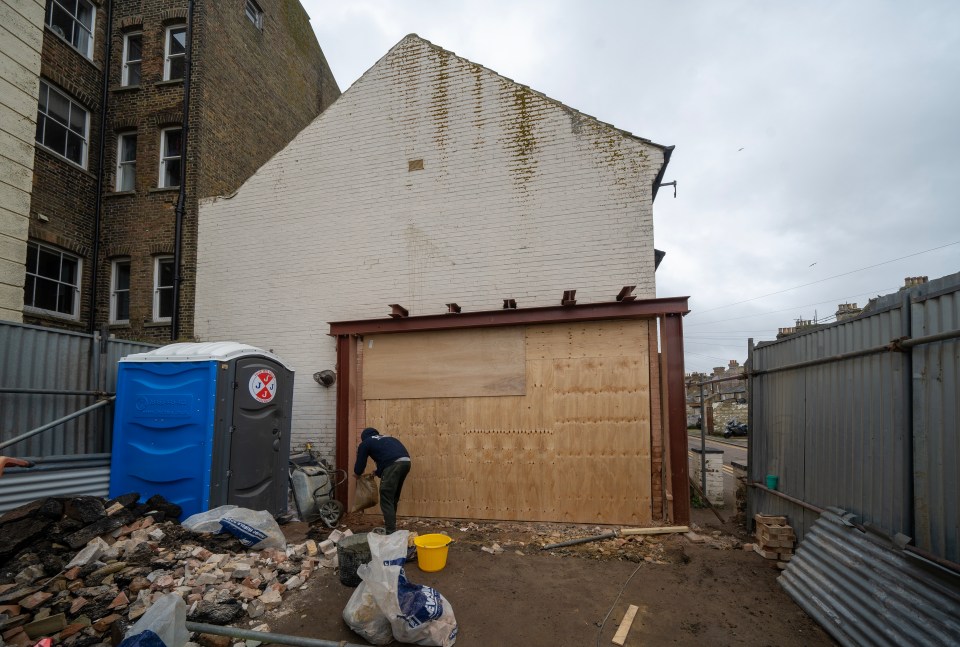 Construction worker removing debris from a building site.