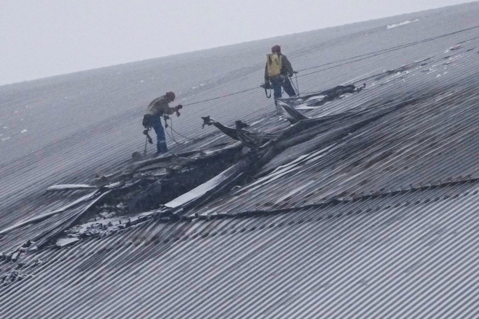 Workers repairing a damaged roof.