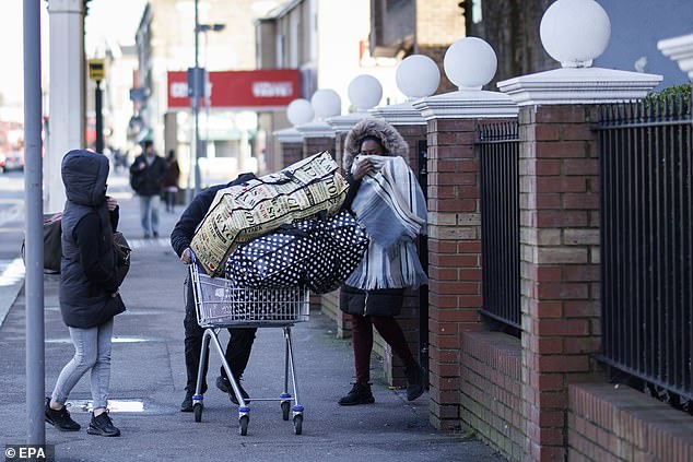 Asylum seekers carry their belongings out of a London hotel operated by Clearsprings in January 2024 after it told them their rooms were being freed up