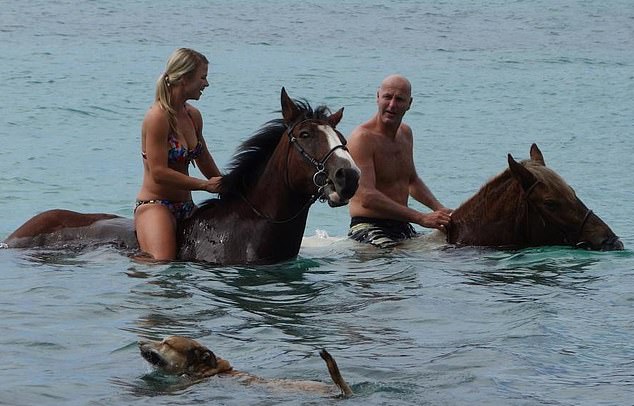 Mr King spends a lot of his time on luxurious holidays with his Latvian girlfriend Lolita Lace (pictured together riding horses on the beach)