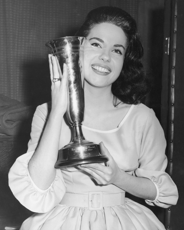 Black and white photo of Jacqueline Boyer holding her Eurovision Song Contest trophy.