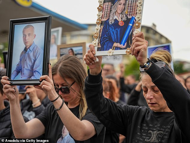 Two protestors hold photos of loved ones lost in the Pulse nightclub fire as they march in Kocani, the town in which the fire took place