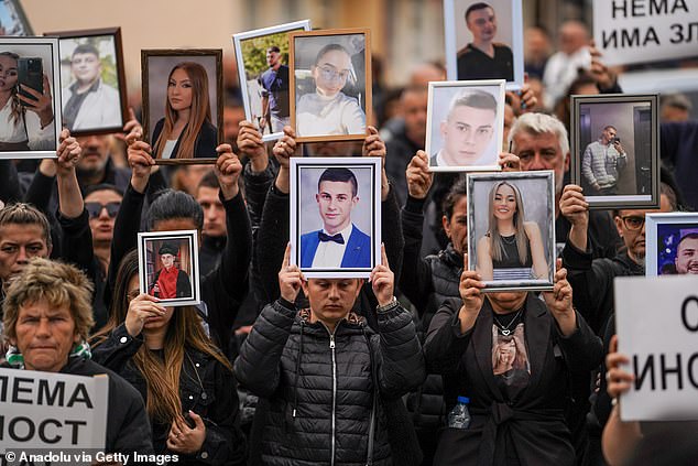 Relatives and parents of the 62 people killed in the blaze hold aloft photographs of their late loved ones