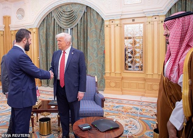 President Donald Trump dances onstage at the Al Udeid Air Base outside of Doha in Qatar. Camo mesh was draped throughout a hangar and Trump stood onstage next to a Q-9 Reaper drone