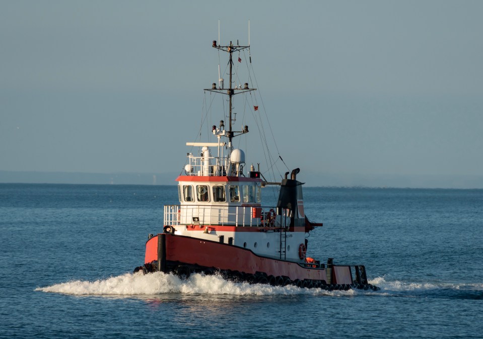 Red and white tugboat on the water.