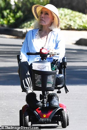 She kept it casual wearing a pair of gray trousers as well as a light blue shirt and black slippers
