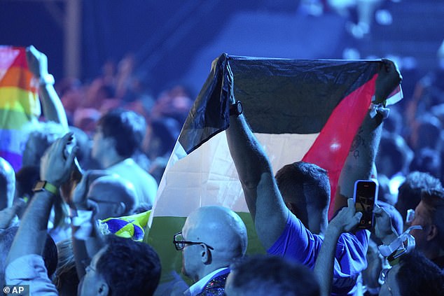 A Palestinian flag is held up in the audience as Yuval Raphael from Israel performs the song 'New Day Will Rise'
