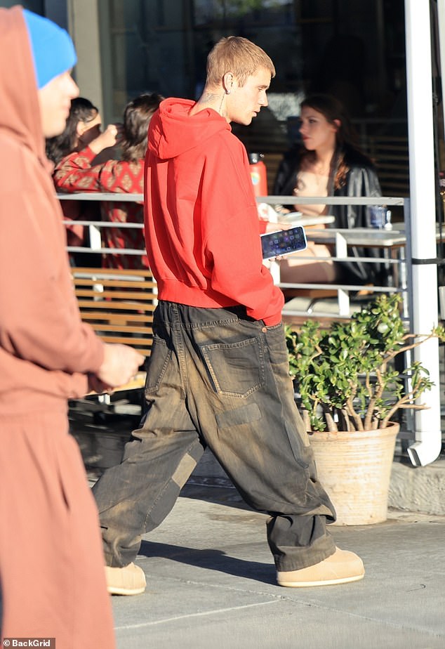 He was characteristically dressed down in a baggy pair of dusty jeans, a loose-fitted rust-colored hoodie
