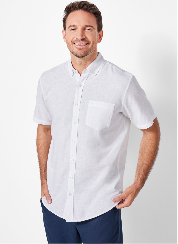 Man smiling and wearing a white linen shirt.