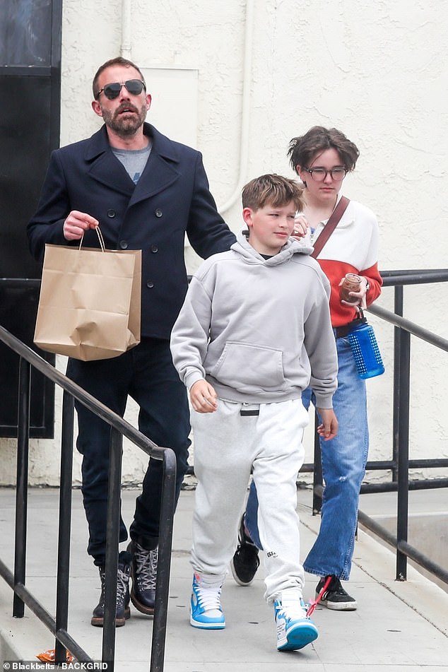 Finn rocked a white and orange sweatshirt, blue jeans, and a brown belt