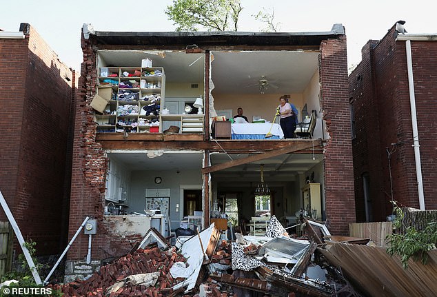 Pictured: Residents inspect their home after a tornado completely tore off the back wall of a two-story house in St. Louis, Missouri