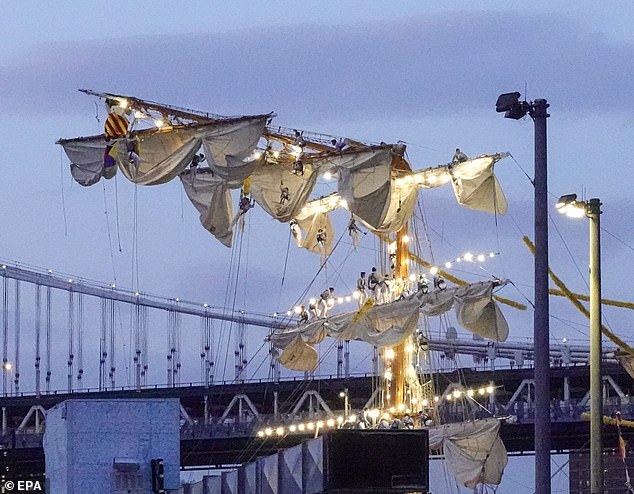 Sailors can be seen dangling from the masts of the Cuauhtémoc, a Mexican Navy training boat, as it sits in the East River