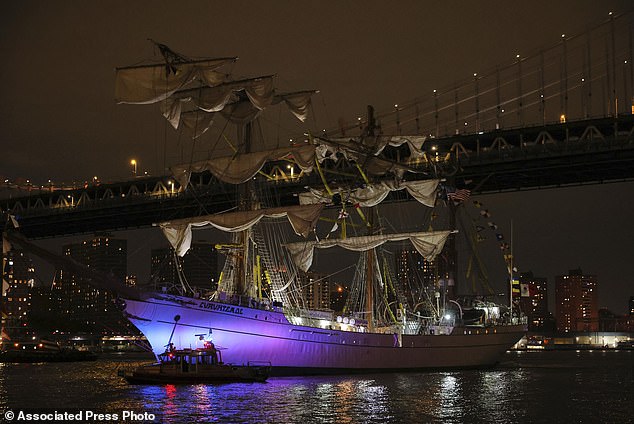 A New York Police Department harbor unit passes in front of the Cuauhtémoc, a masted Mexican Navy training ship as it sits stranded