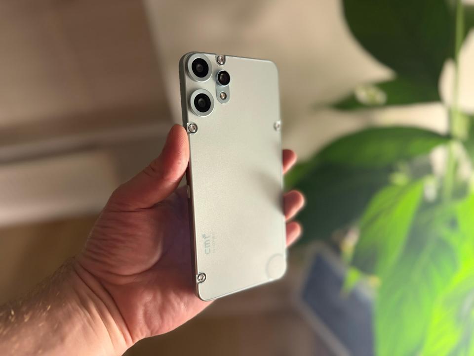 Person holding a light-grey smartphone.