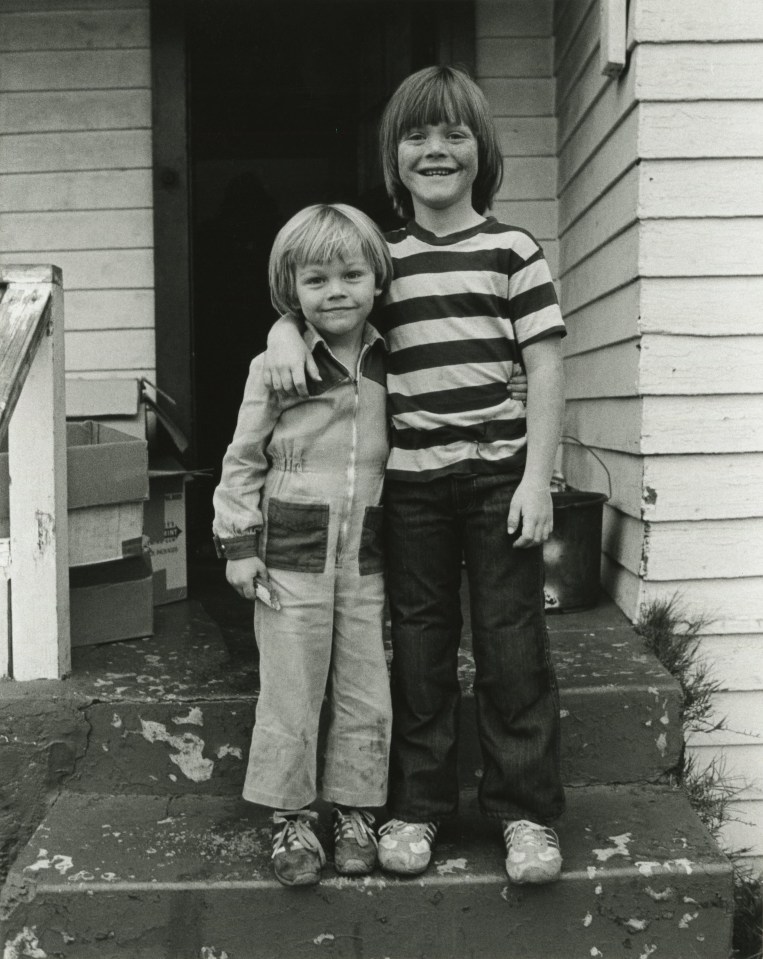 Black and white photo of Leonardo DiCaprio and his stepbrother posing on steps outside their home.