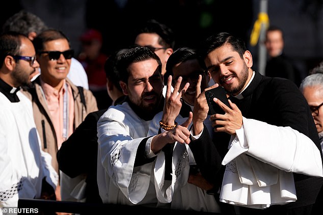 Priests pose for a selfie ahead of Pope Leo XIV's inaugural Mass in Saint Peter's Square