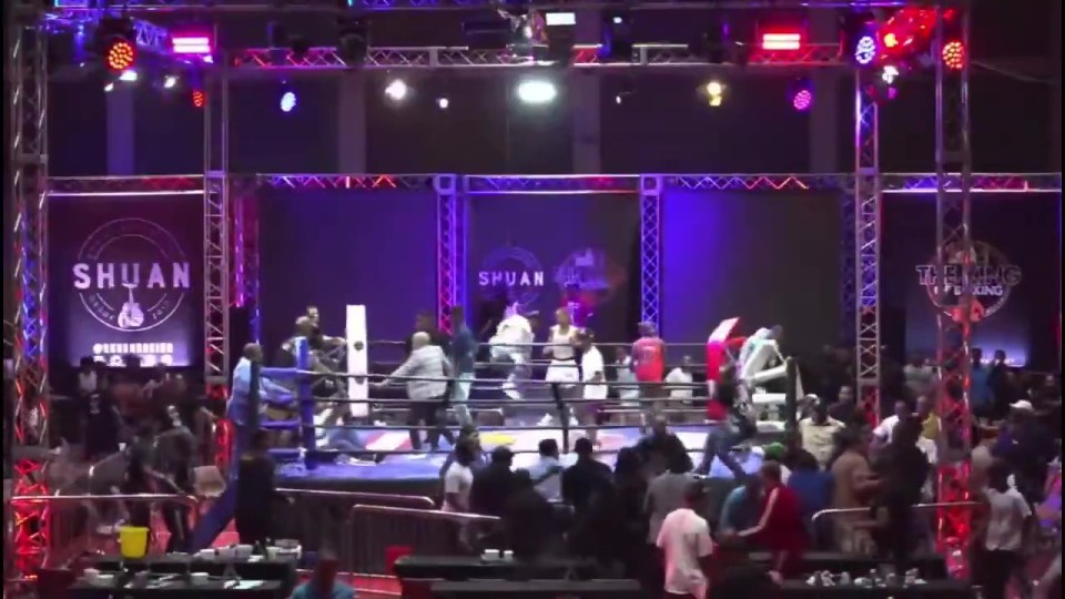 A boxing referee being attacked in the ring by several men.