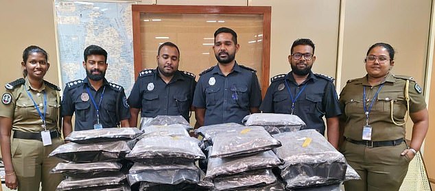 The authorities pose with what they say is £1.15million of cannabis in vacuum packed bags seized from Miss Lee