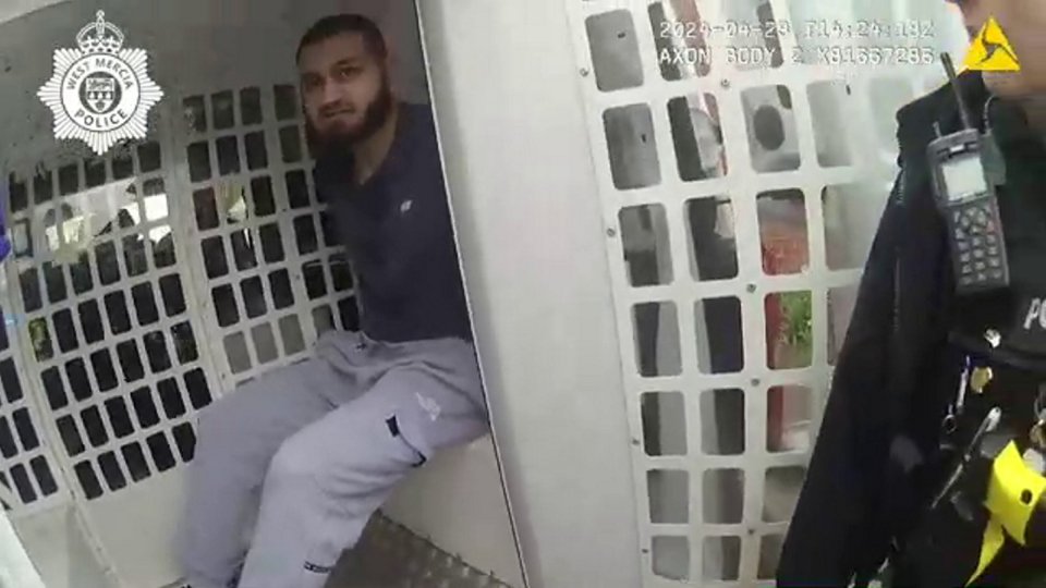Arrested man in police vehicle.