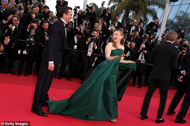Mia looked gorgeous in her green gown as actor Rupert Friend helped her with the skirt