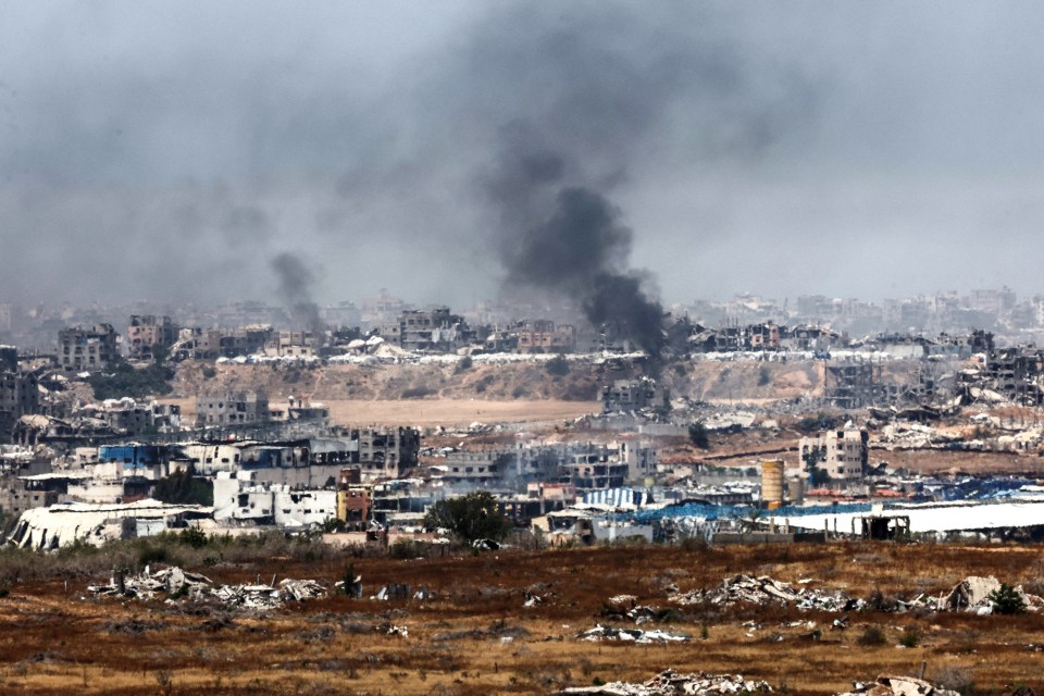 Smoke billows over destroyed buildings in Gaza.