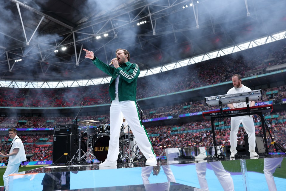 Olly Murs performing on stage at a stadium.